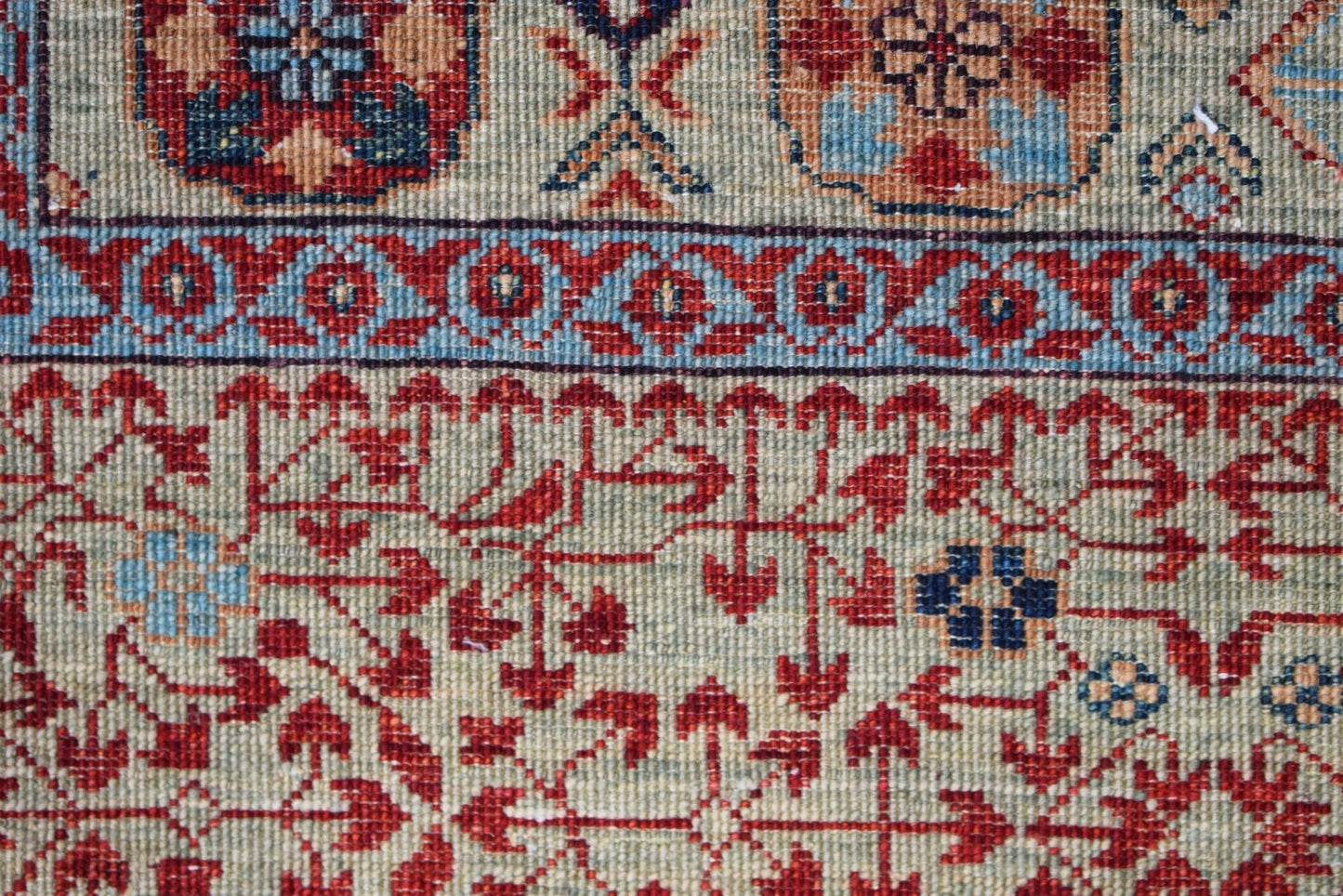 A close-up of a handmade Afghan Balkh rug featuring intricate red and blue Mamluk patterns.