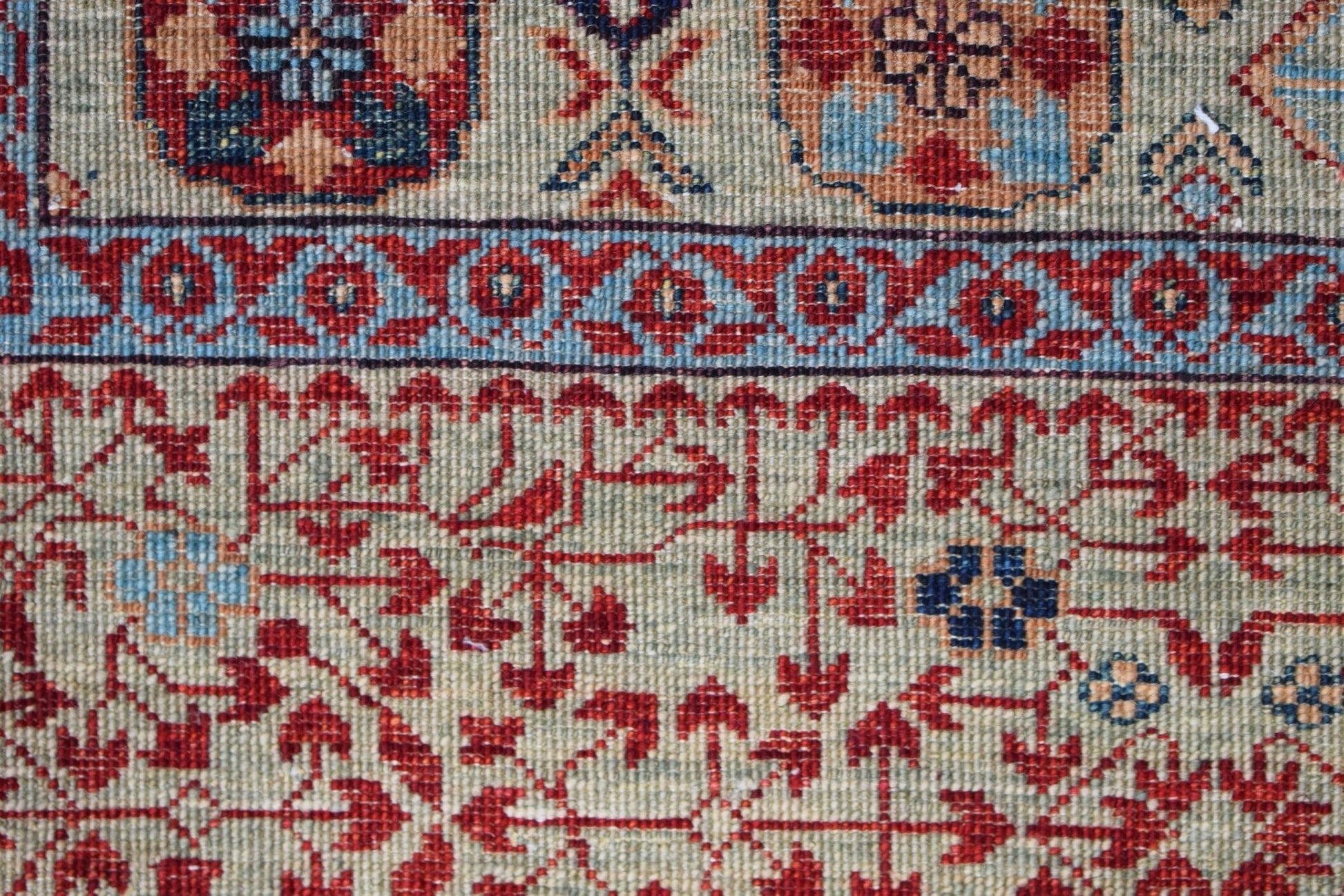 A close-up of a handmade Afghan Balkh rug featuring intricate red and blue Mamluk patterns.