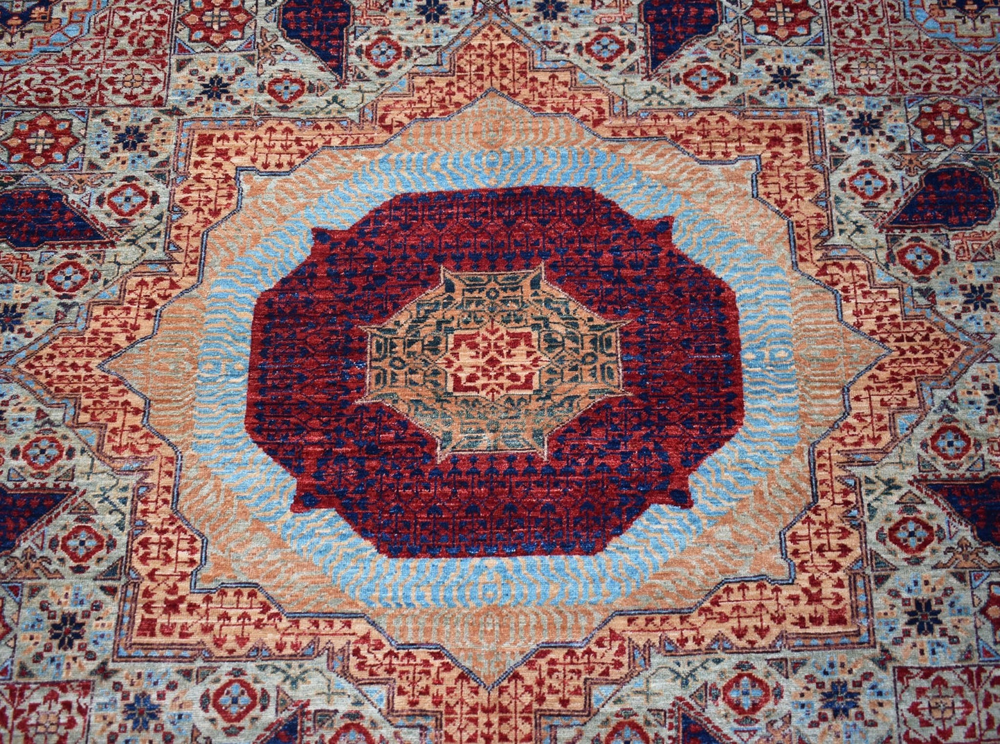 Handwoven Afghan Balkh rug featuring a detailed Mamluk medallion in red, blue, and tan wool.