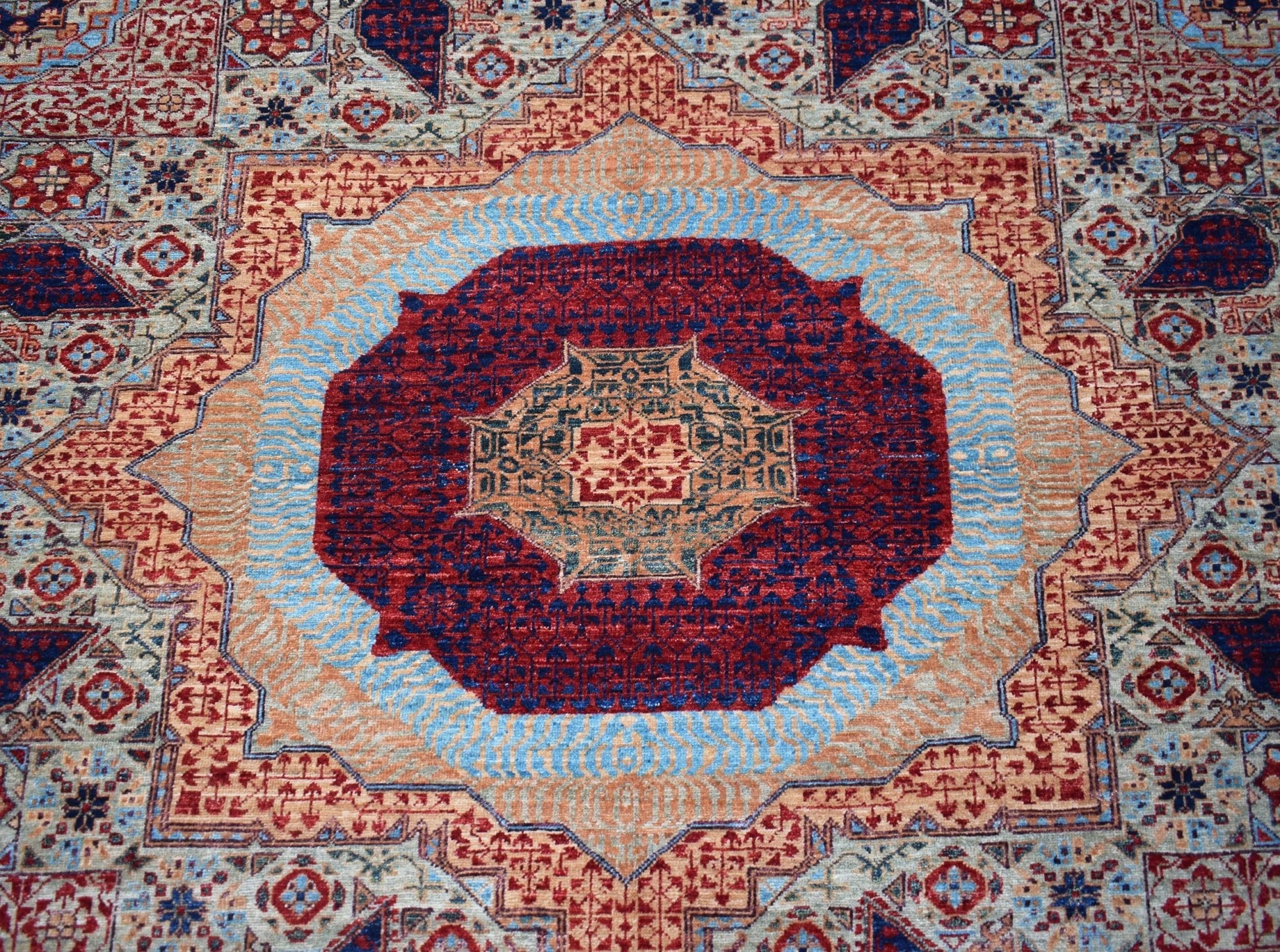 Handwoven Afghan Balkh rug featuring a detailed Mamluk medallion in red, blue, and tan wool.