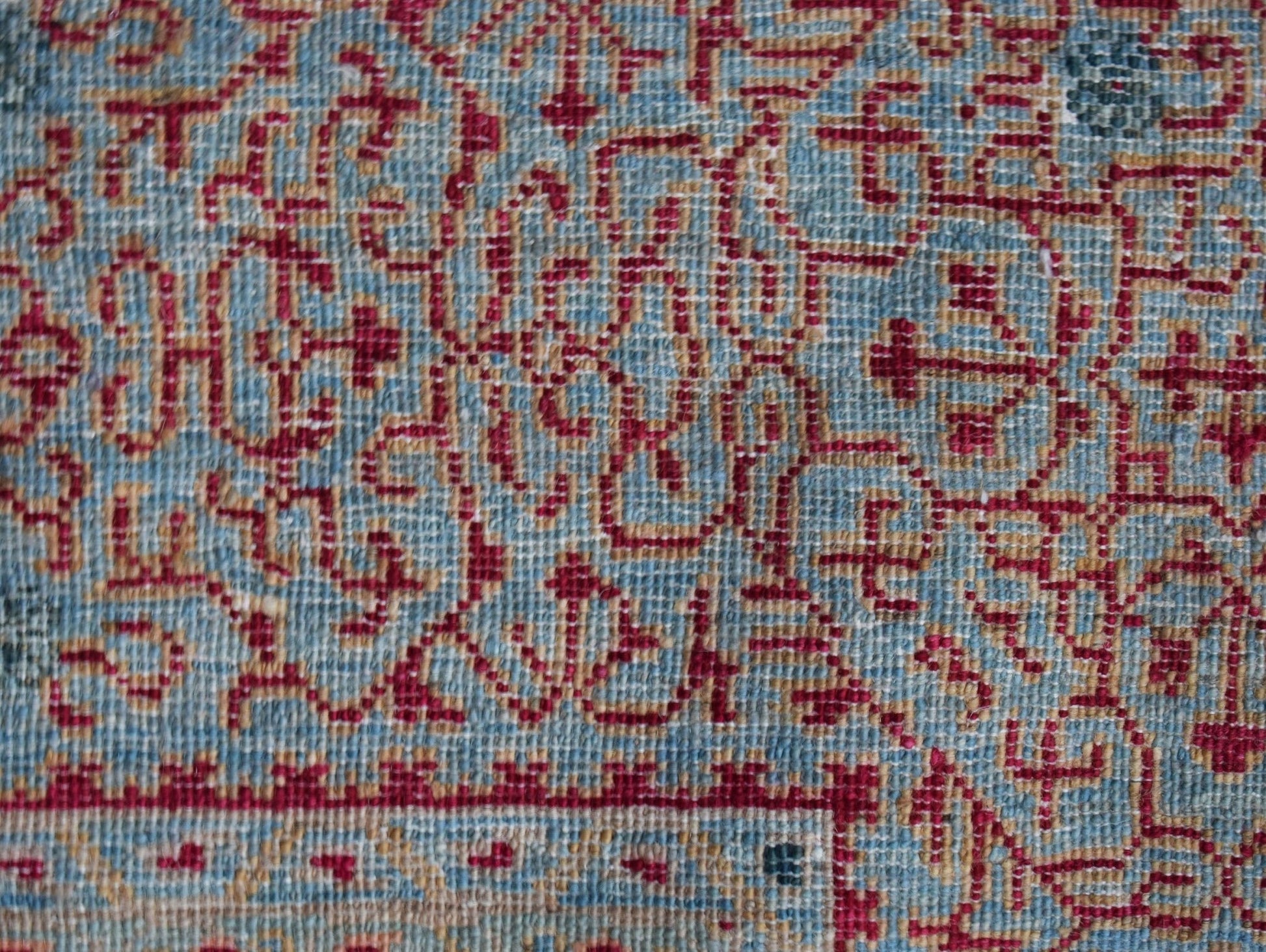 A close-up of a handmade Afghan Balkh rug featuring a detailed red Mamluk pattern on a blue base.