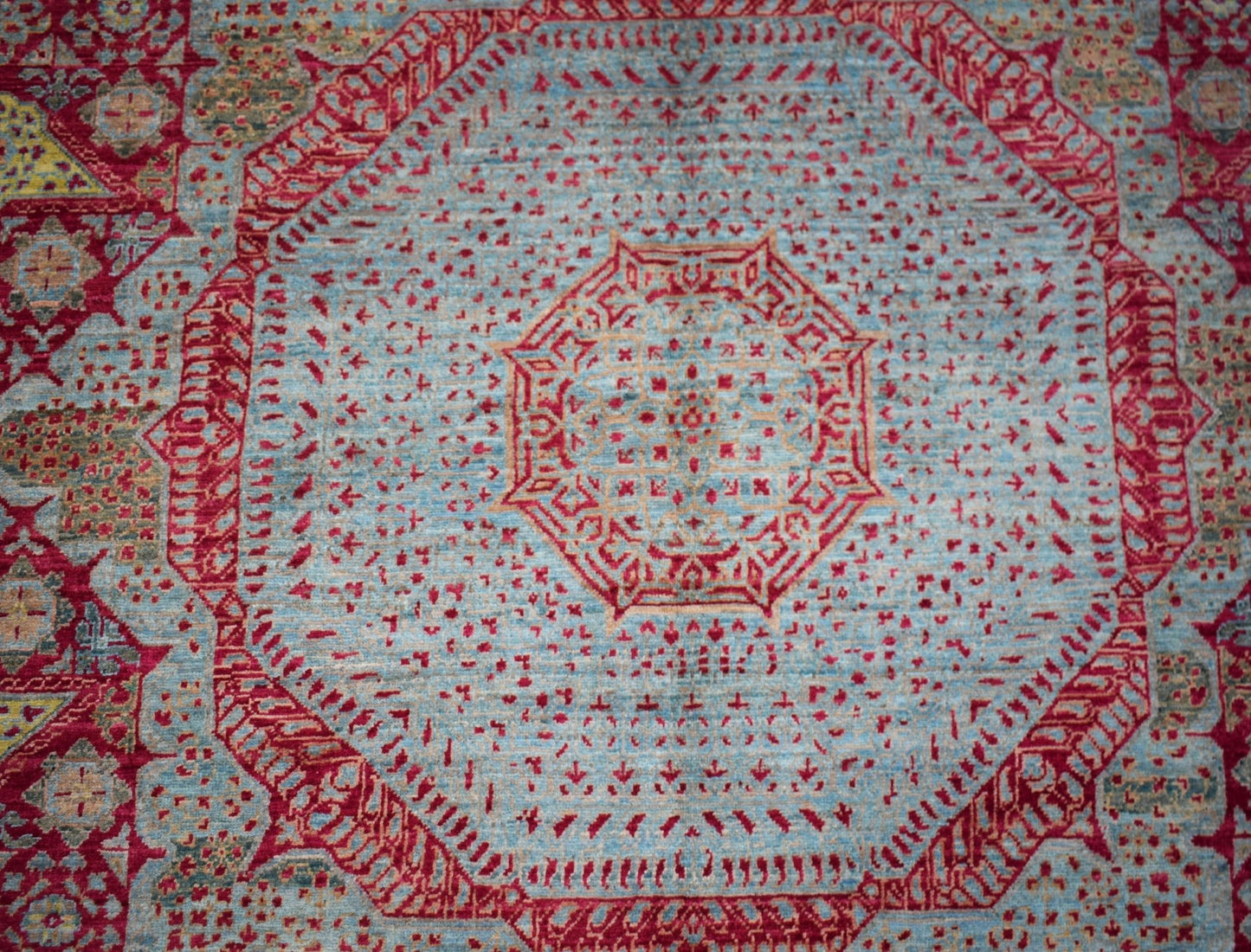 Handwoven Afghan Balkh rug featuring a detailed red Mamluk medallion on a light blue field.