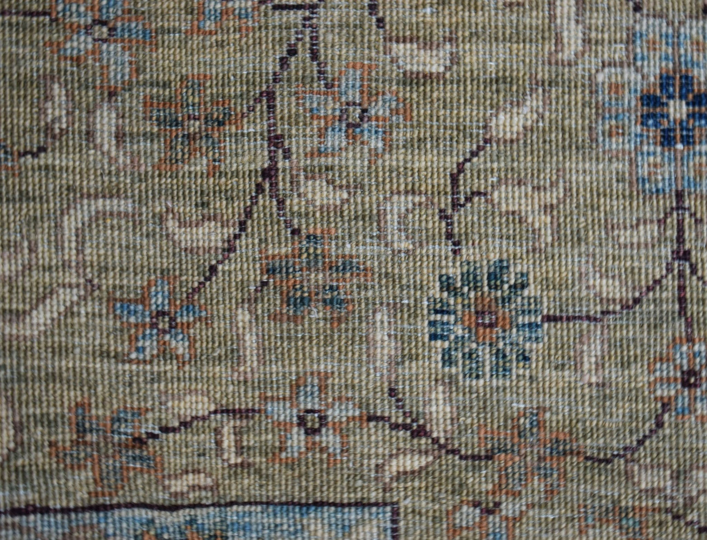 A close-up of a handwoven Afghan rug featuring a detailed Mamluk floral pattern in earthy tones.