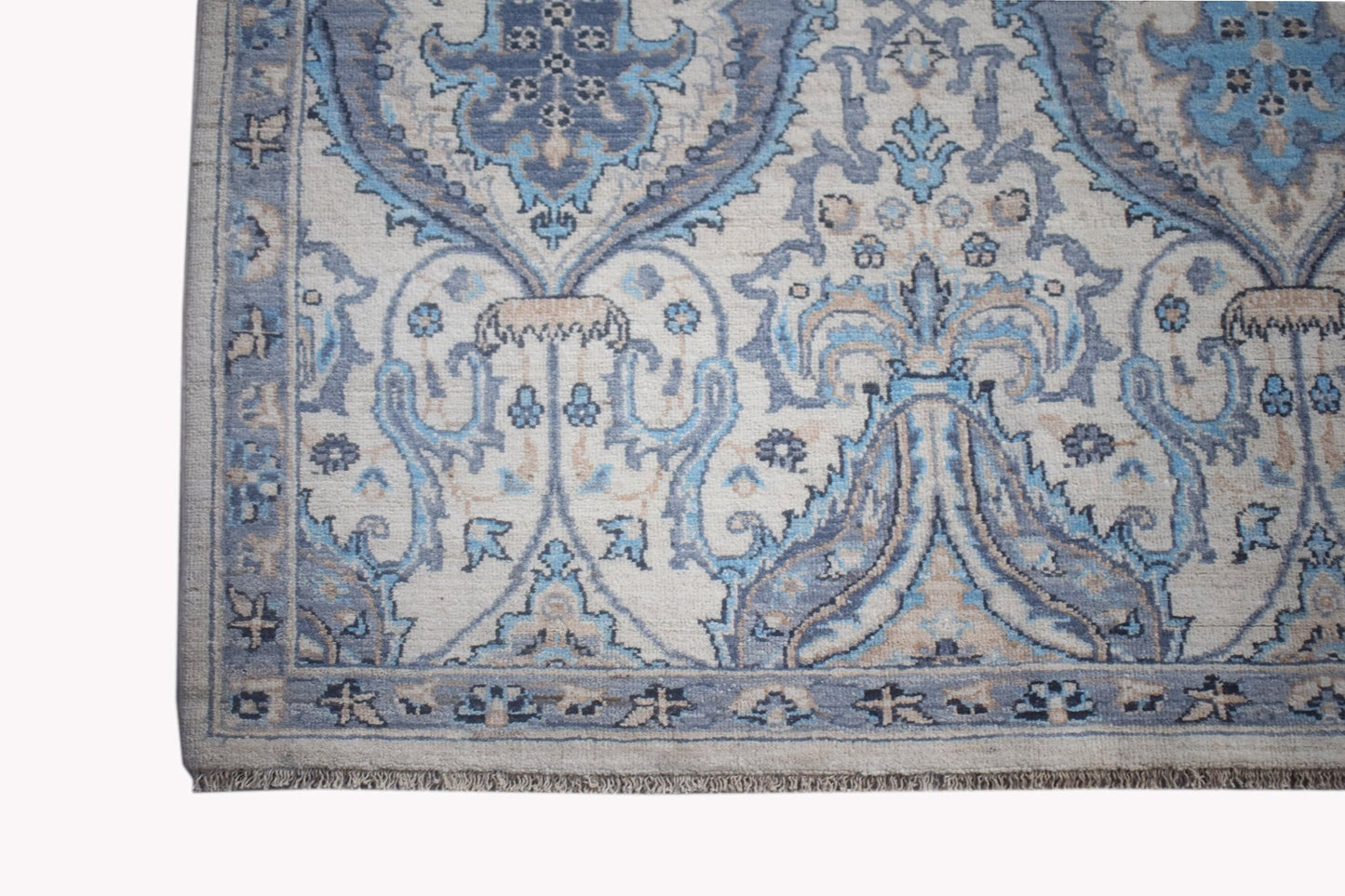 A handwoven Afghan Balkh rug featuring a traditional blue and beige floral pattern.