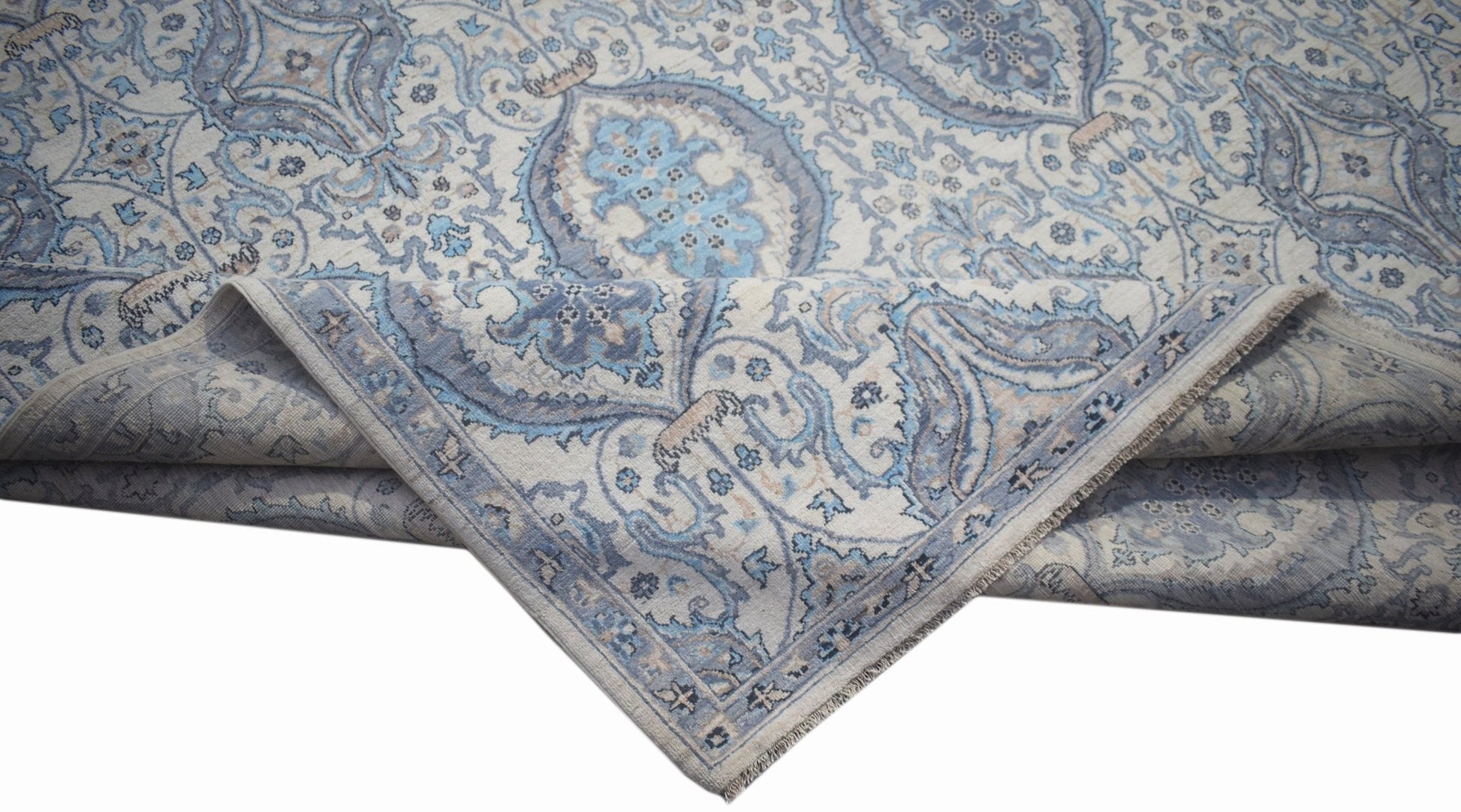 A handwoven Afghan Balkh rug featuring a traditional blue and cream floral pattern.