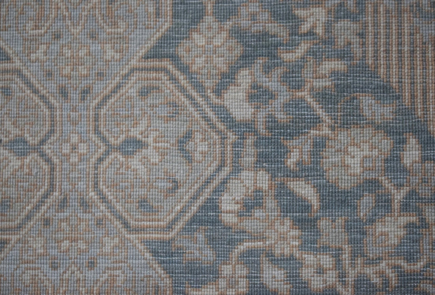 A handwoven Afghan Balkh rug featuring a traditional floral pattern in muted blue and beige tones.