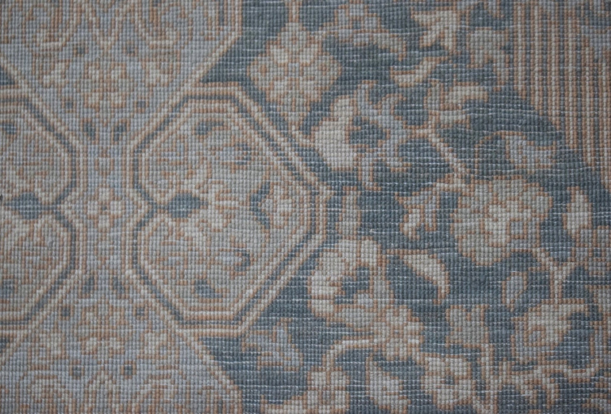A handwoven Afghan Balkh rug featuring a traditional floral pattern in muted blue and beige tones.
