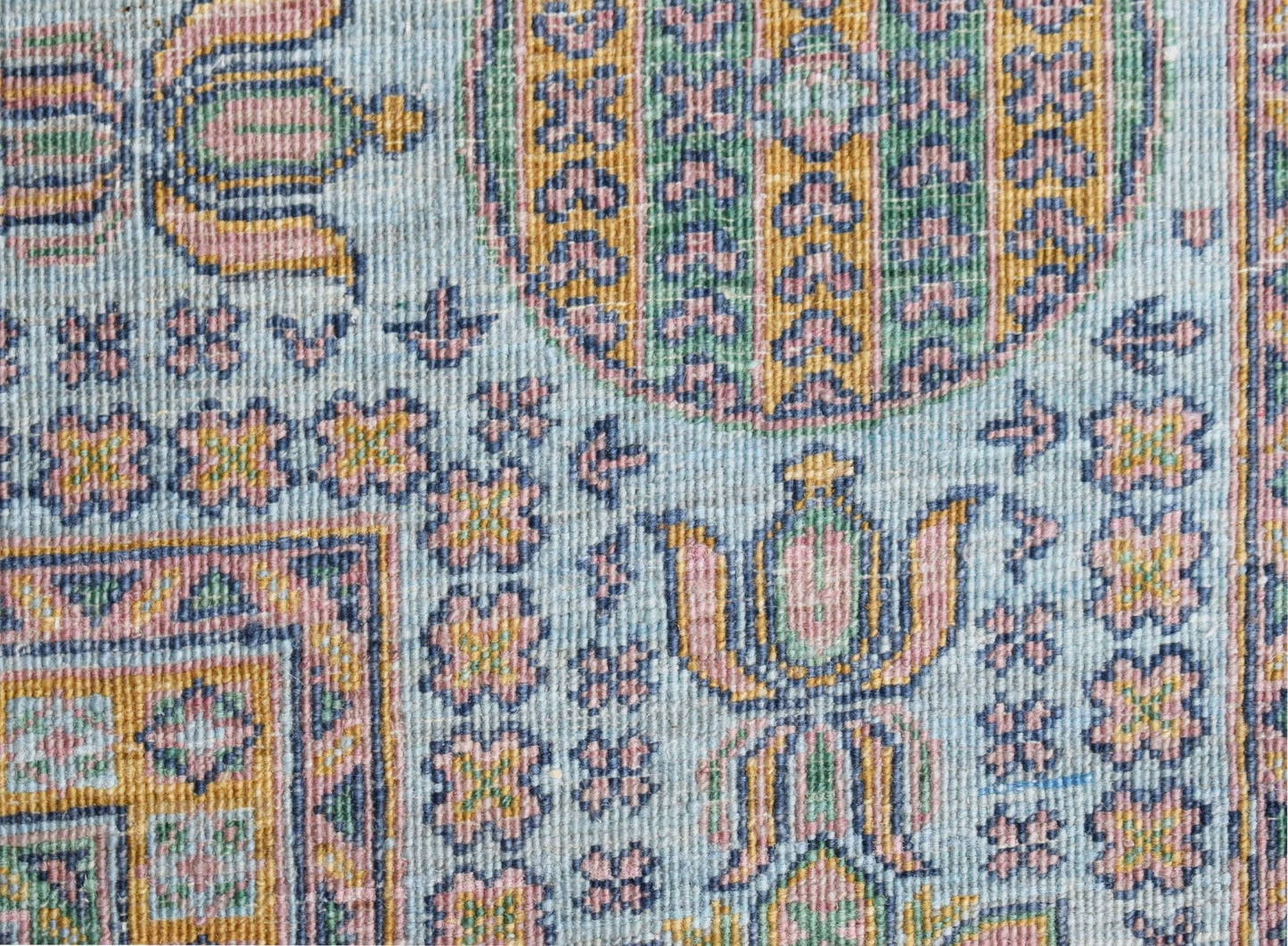 A close-up of a handwoven Afghan Chobi rug featuring intricate floral patterns in soft pastel tones.