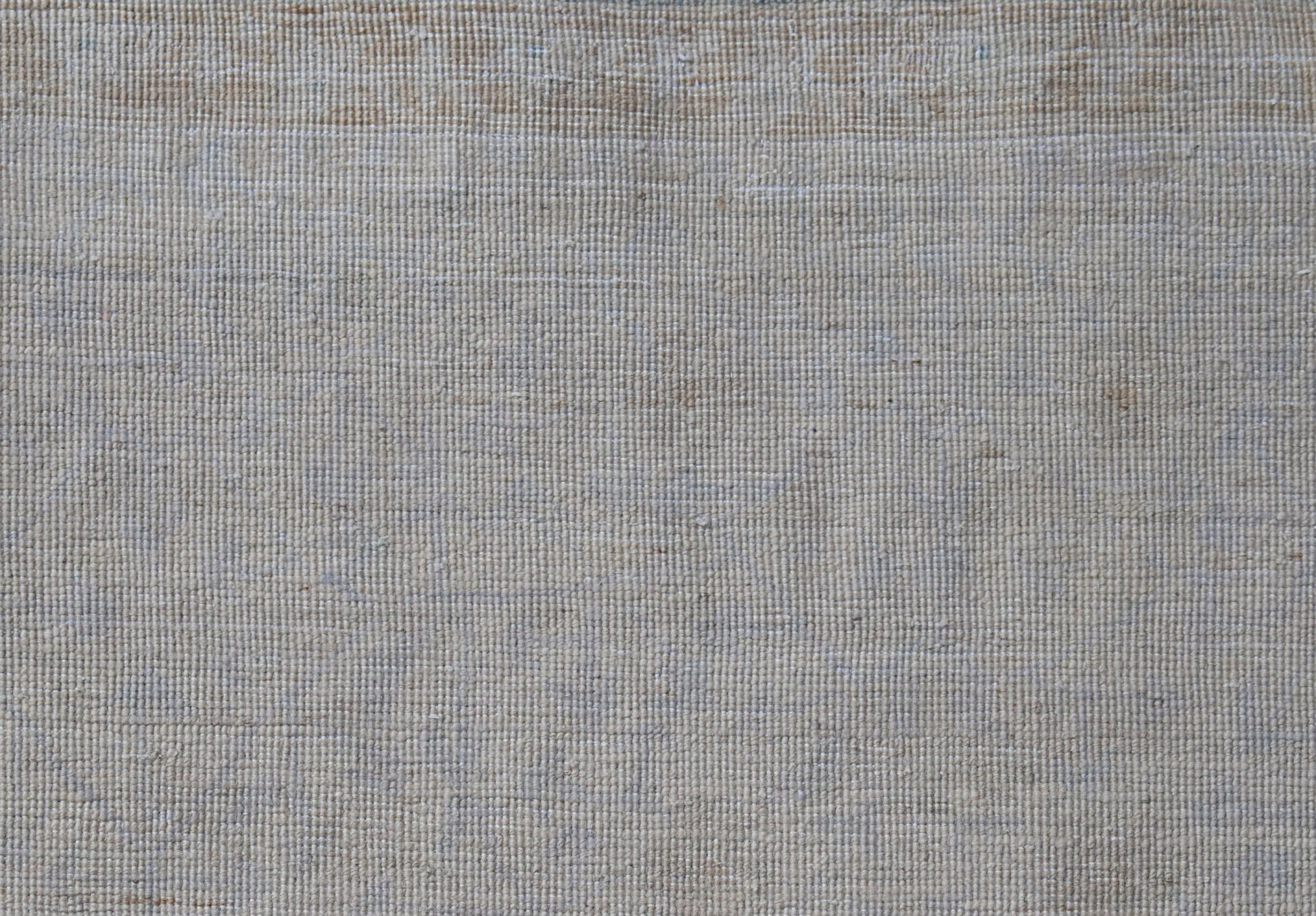 A close-up view of a handwoven Afghan Balkh rug featuring a neutral, textured wool weave.