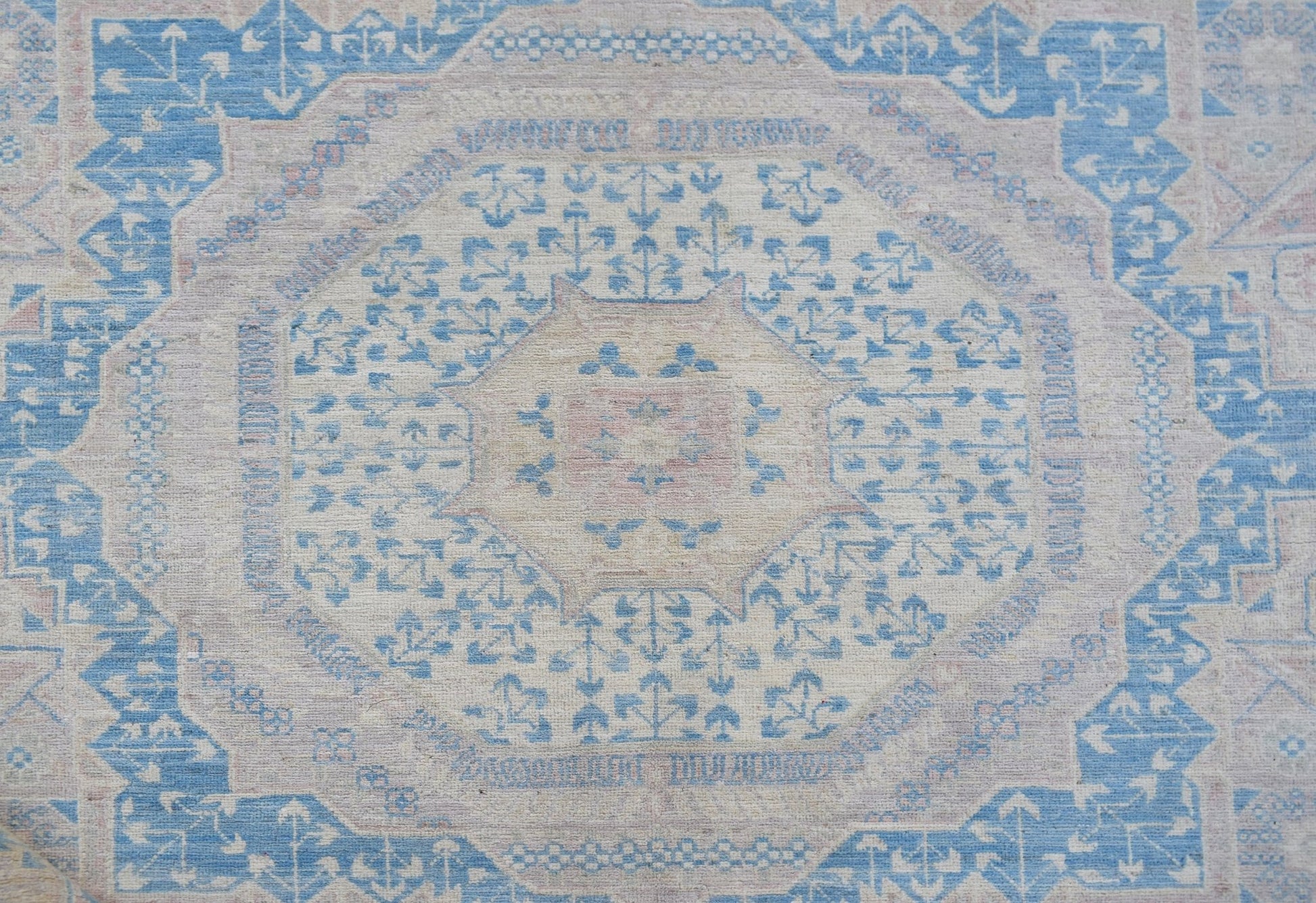 Handwoven Afghan Balkh rug featuring a traditional geometric pattern in soft blue and cream tones.