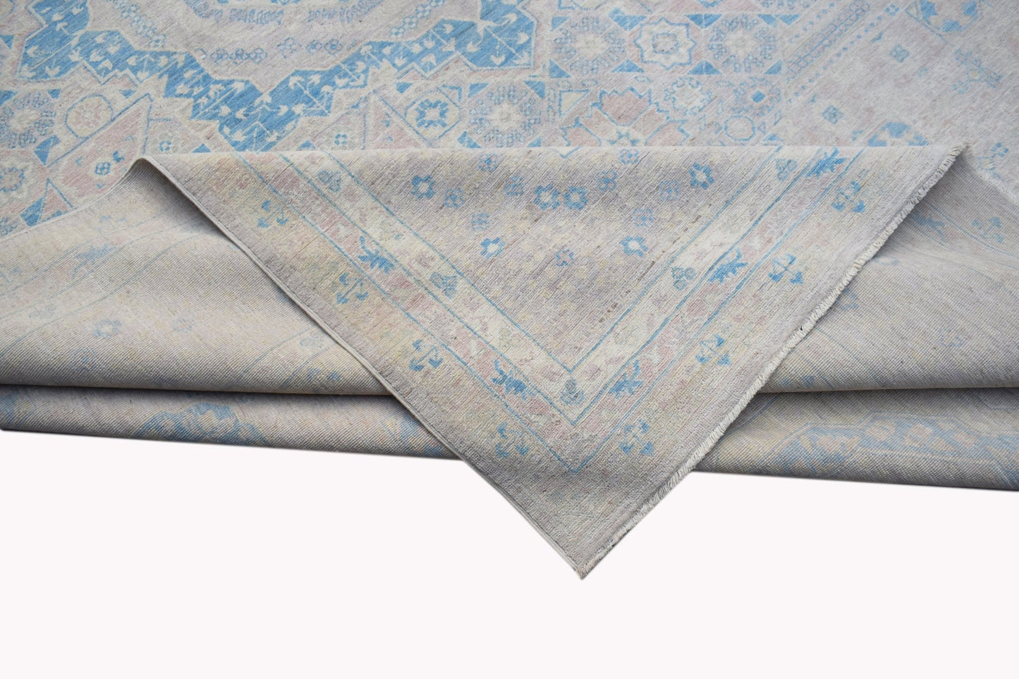 A handwoven Afghan Balkh rug featuring a traditional pattern in soft blue and beige tones.