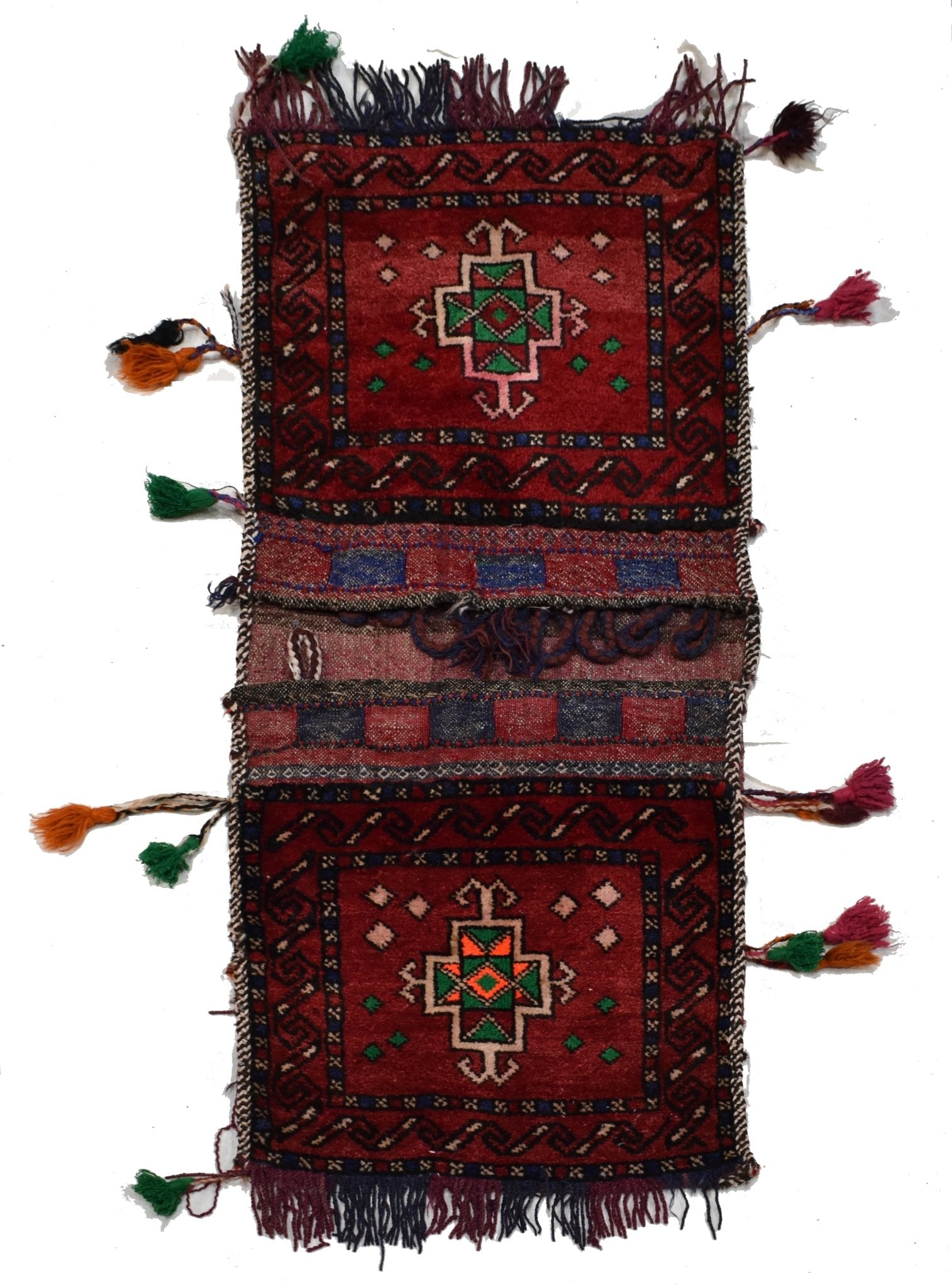 A vintage handmade Afghan wool saddle bag featuring two red panels with geometric tribal motifs.